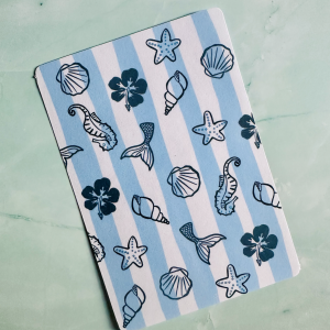 Insert décoratif Kindle "Ocean Vibes" avec motifs marins doodle bleu marine : coquillages, queues de sirène, hippocampes et hibiscus sur fond rayé bleu ciel et blanc