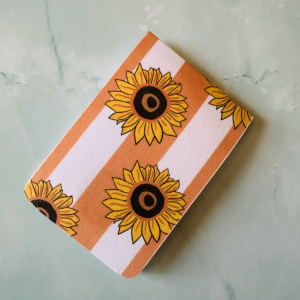 Marque-page magnétique "Sun Flowers" avec tournesols jaunes en pattern sur fond rayé terracotta et blanc, coins arrondis, posé sur fond marbre vert