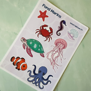 Planche de stickers "Fond Marins" 12x17 cm : étoile de mer rouge, crabe, hippocampe violet, tortue marine verte, méduse rose, poisson clown, pieuvre bleue et coquillage nacré sur fond lilas aquatique