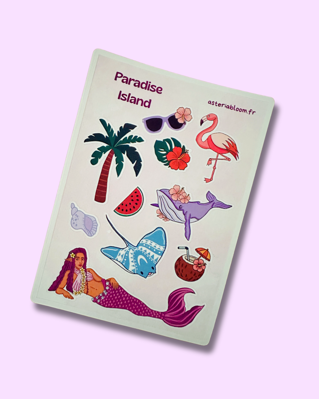 Planche de stickers "Paradise Island" 12x17 cm : sirène polynésienne aux cheveux violets, flamant rose, raie manta bleue, palmier, baleine fleurie et noix de coco cocktail sur fond blanc crème, posée sur fond rose lilas
