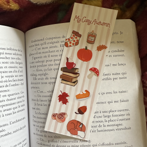 Marque-page recto-verso "My Cozy Autumn / The Cozy Reader Club" : recto motifs automnaux kawaii (citrouille, bougie, champignon, renard) sur fond rayé rose poudré, verso ticket vintage "Admit One Reader" avec cinnamon rolls et feuilles d'automne, posés sur un livre ouvert